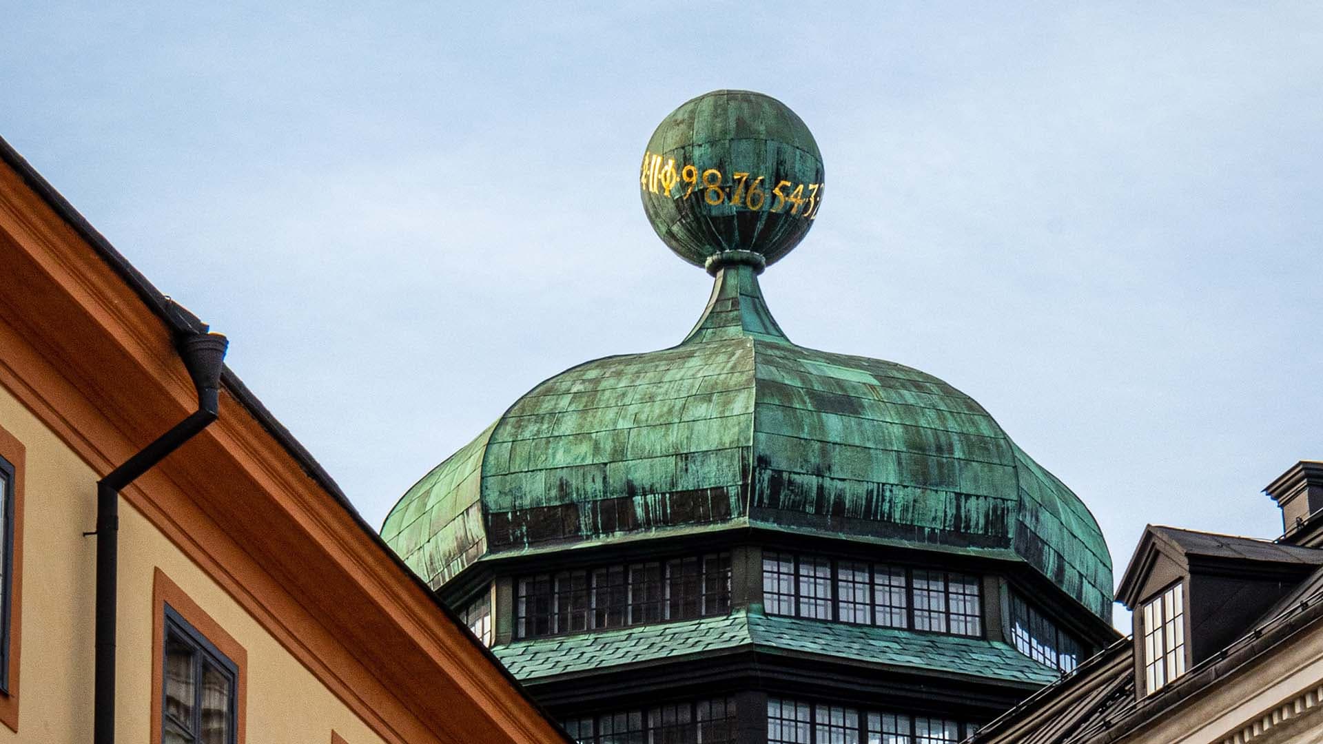 Historic building detail featuring a copper-clad dome and sphere.