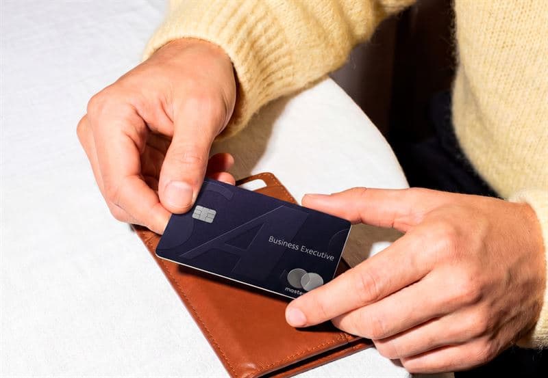 The SAS Business Executive Card, held by two hands above a brown leather wallet.