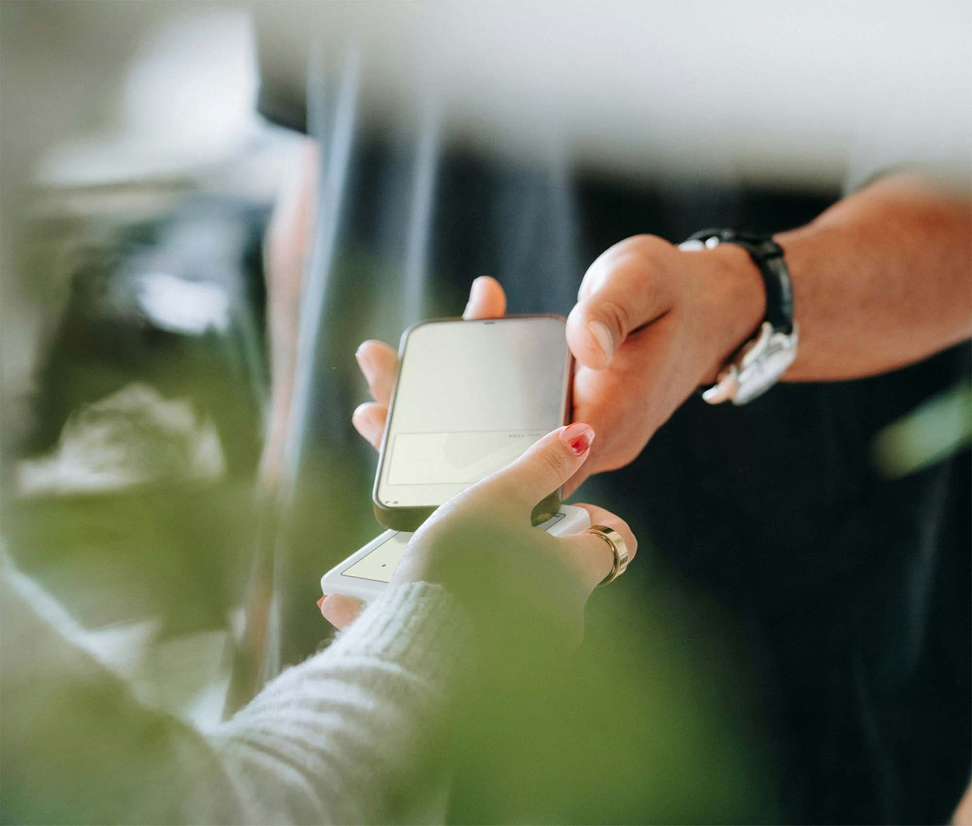 Person paying with a digital card using their mobile phone.