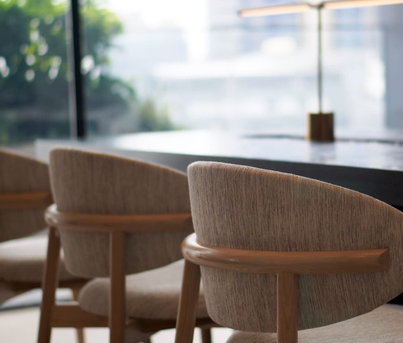 Modern boardroom with chairs and a meeting table in a bright office setting.